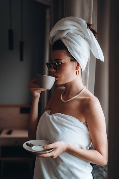 Mädchen nach der Dusche in ein Handtuch gewickelt und Kaffee getrunken - Foto, Bild