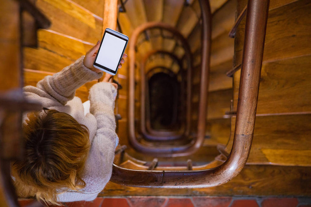 Дівчина використовує мобільний телефон на сходах у будівлі
. - Фото, зображення