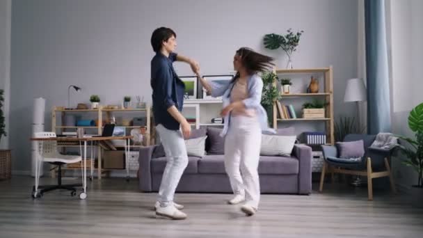 Young man and woman dancing laughing enjoying married life together - Filmagem, Vídeo