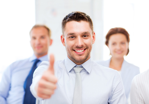 Businessman in office showign thumbs up - Photo, image
