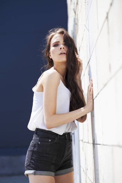 Pretty young brunette model in white summer blouse and jeans, su - Φωτογραφία, εικόνα