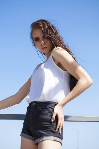 Bonita joven modelo morena en blusa de verano blanca y jeans, su
 - Foto, imagen