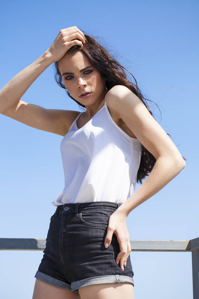 Pretty young brunette model in white summer blouse and jeans, su - Фото, зображення