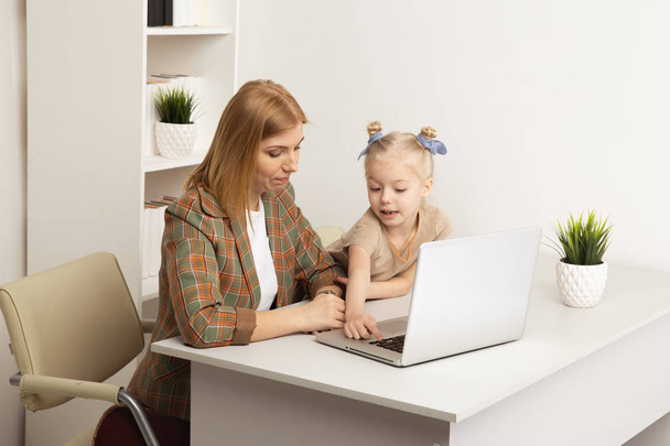 Μητέρα και κόρη παίζουν υπολογιστή μαζί στο σπίτι. - Φωτογραφία, εικόνα
