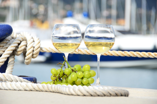 Pair of wineglasses and grapes against the yacht pier of La Spez - Photo, Image