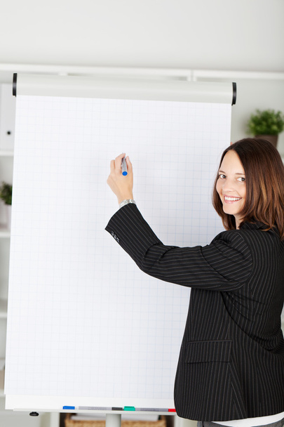 Smiling businesswoman with a blank flipchart - Foto, imagen