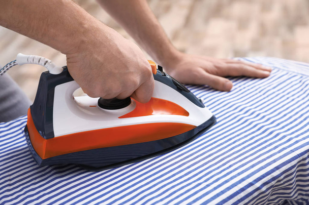 Man ironing shirt on board at home, closeup - Foto, Imagem