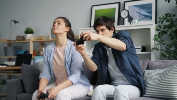 Joyful couple playing video game at home having fun relaxing in leisure time - 映像、動画