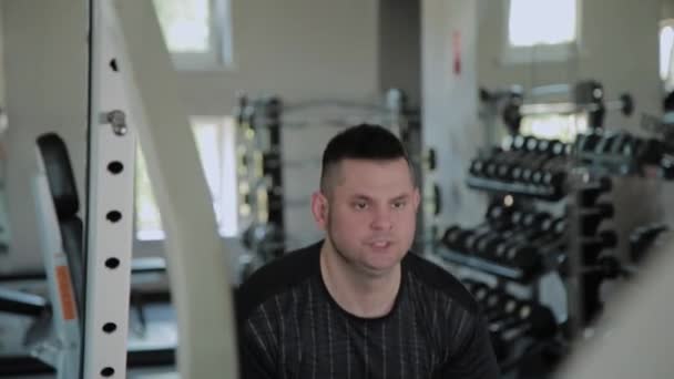Hombre adulto con sobrepeso realiza levantamiento de pesas en el gimnasio
. - Metraje, vídeo