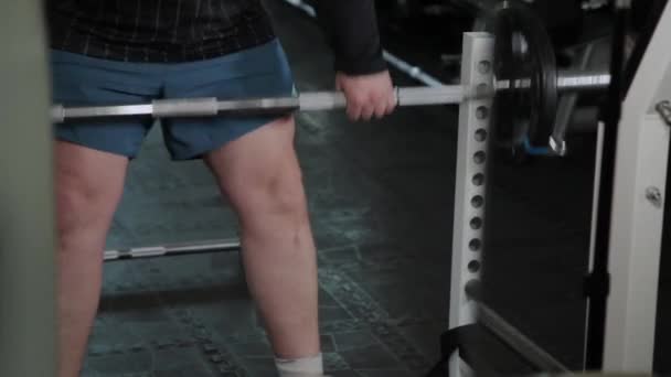 Hombre adulto con sobrepeso realiza levantamiento de pesas en el gimnasio
. - Metraje, vídeo
