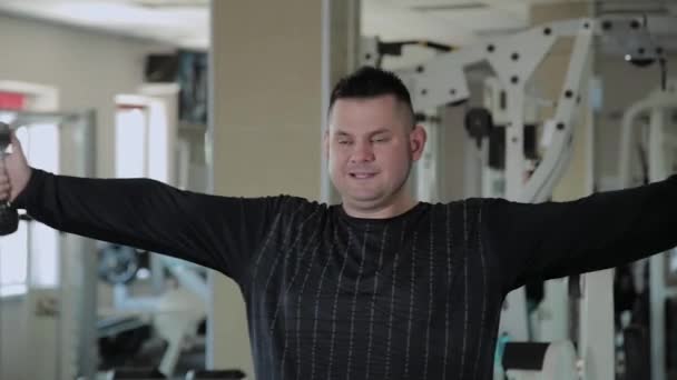 Adult man with overweight performs breeding with dumbbells. - Footage, Video