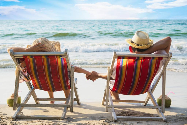 Χαλαρώστε ζευγάρι που βρίσκονται στην παραλία Chiar με κύμα θαλάσσιων κυμάτων-άνθρωπος και γυναίκα έχουν διακοπές στη θάλασσα φύση έννοια - Φωτογραφία, εικόνα