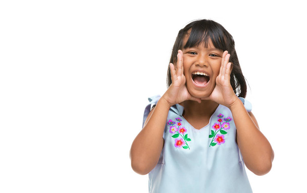 Cute asian dark little girl making a funny emotion on face . - Foto, imagen