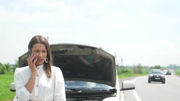 une belle femme tombe en panne de voiture elle utilise son téléphone cellulaire pour demander de l'aide - Séquence, vidéo