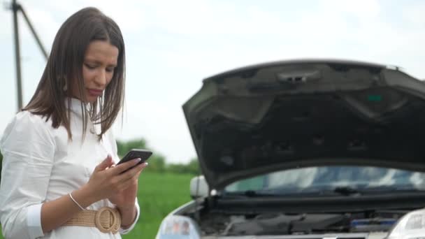 Un coche atractivo de los womans se rompe y utiliza su teléfono celular para pedir ayuda. - Metraje, vídeo