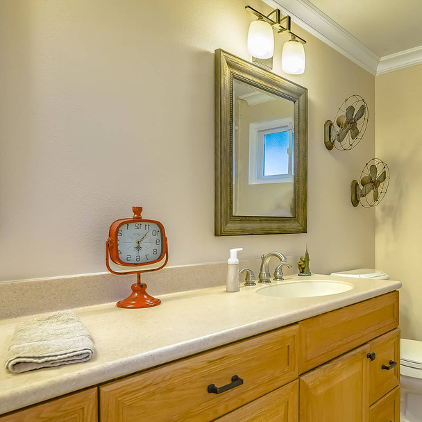 Cadre carré Double vanité avec armoires en bois à l'intérieur d'une salle de bain avec petite fenêtre
 - Photo, image