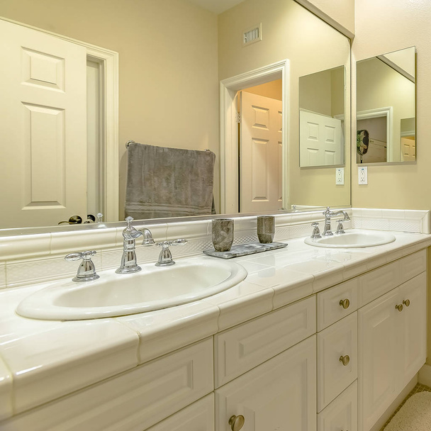 Frame Square Interior of a small bathroom with a double sink vanity area and wood cabinets - Photo, Image