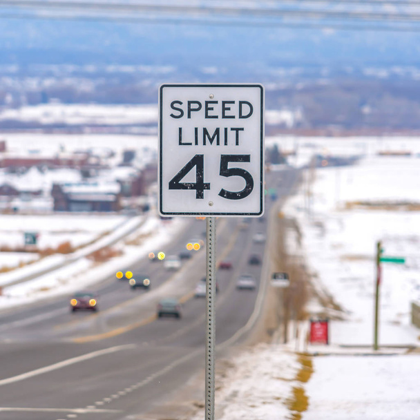Quadrato Primo piano di un segnale di limite di velocità in un'autostrada circondata dalla neve in inverno
 - Foto, immagini