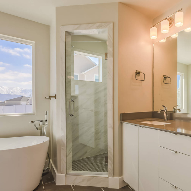 Frame Square interior do banheiro moderno com pia dupla vaidade chuveiro porta de vidro e banheira
 - Foto, Imagem