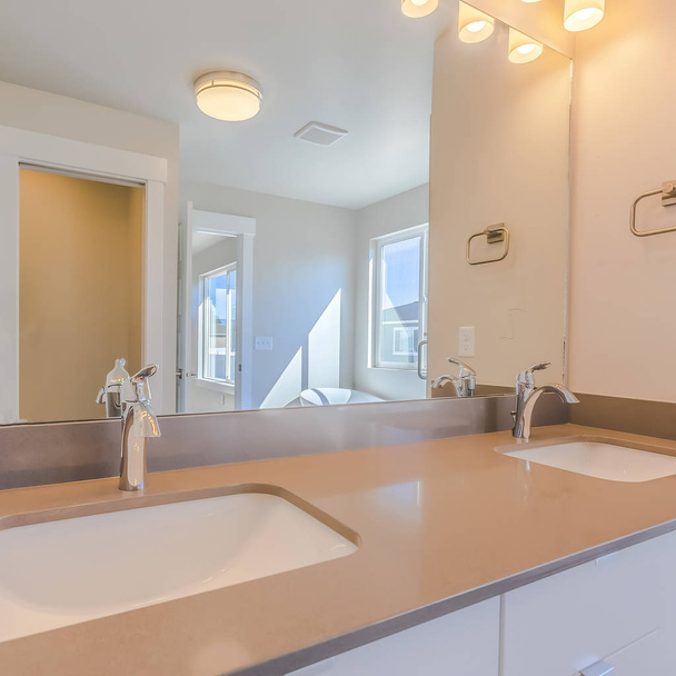 Fregadero doble cuadrado vanidad dentro del moderno cuarto de baño de una casa nueva
 - Foto, Imagen