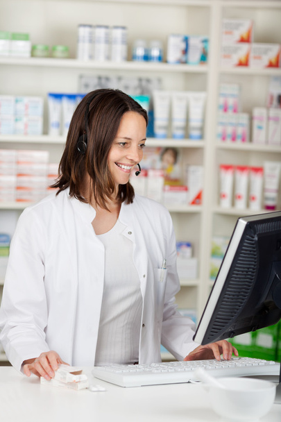 Businesswoman Conversing On Headset In Pharmacy - Foto, Imagem