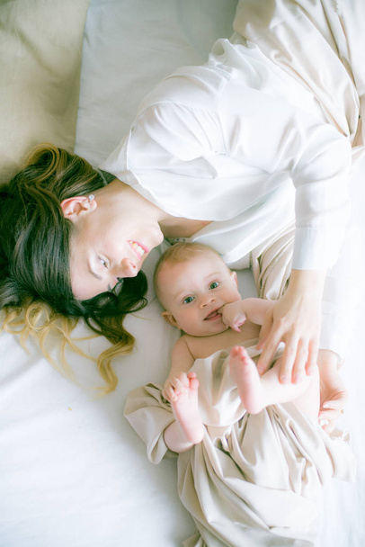 happy family. mother playing with her baby in the bedroom - 写真・画像