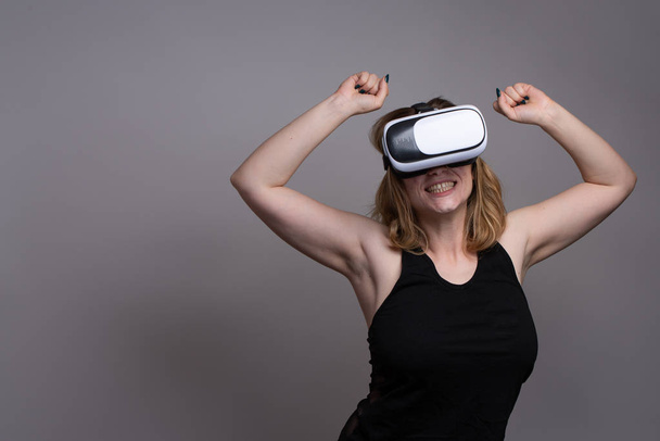 Fille heureuse en utilisant un gadget VR lors d'une simulation de cyberréalité
 - Photo, image
