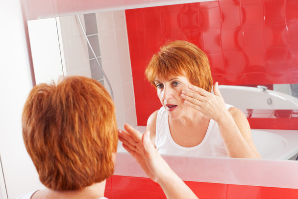 Woman gets cream on face - Foto, immagini