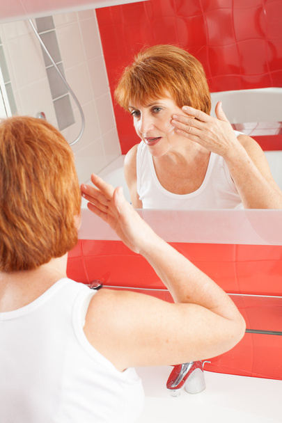 Woman gets cream on face - Foto, imagen