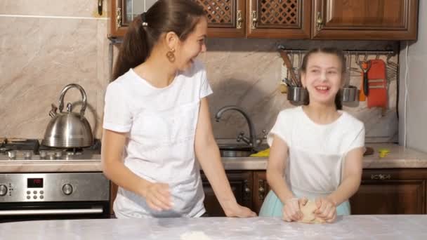 Speelse moeder en tiener meisje is koken samen in de keuken smeren elkaar in meel. - Video