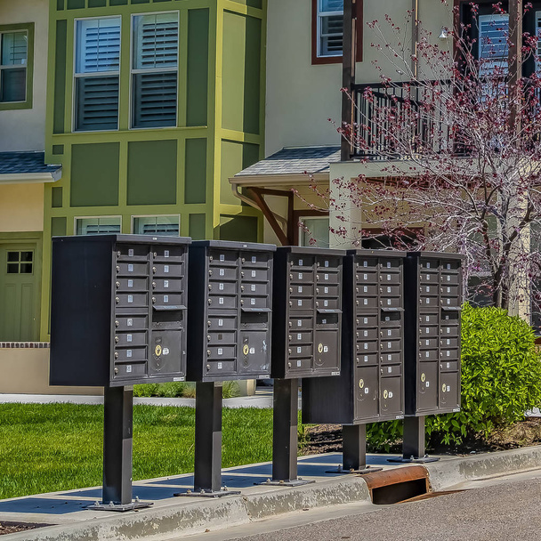Frame Square Cluster boîtes aux lettres sur le trottoir en face de maisons vues par une journée ensoleillée
 - Photo, image