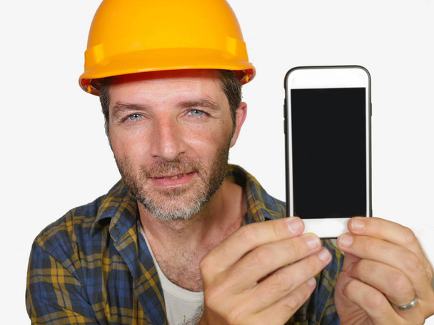 constructor worker in contractor helmet holding mobile phone offering company building and repair services smiling cheerful and confident inviting for calling - Φωτογραφία, εικόνα