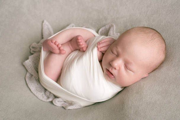 Sweet newborn baby sleeps in a basket. Beautiful newborn baby in a beige diaper - Photo, Image