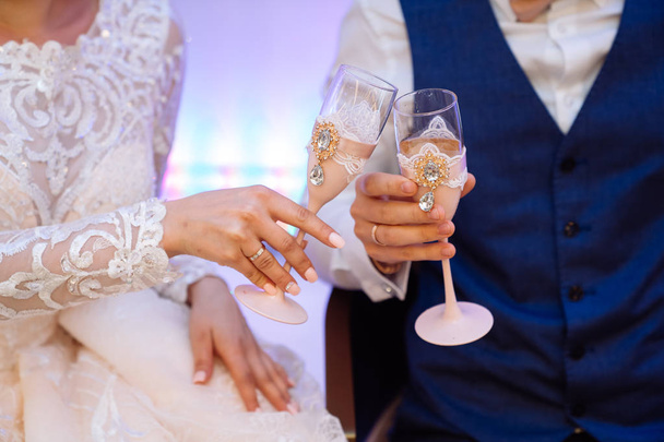Close up glasses of champagne in hands of bride and groom in wedding day - Zdjęcie, obraz