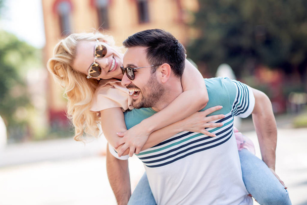 Casal sorridente no amor ao ar livre.Jovem casal feliz abraçando na rua da cidade
. - Foto, Imagem