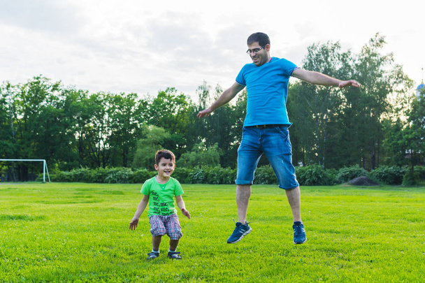 papa et fils sautant sur l'herbe
 - Photo, image