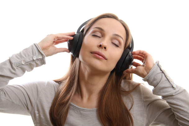 Jeune femme écoutant de la musique avec écouteurs - Photo, image