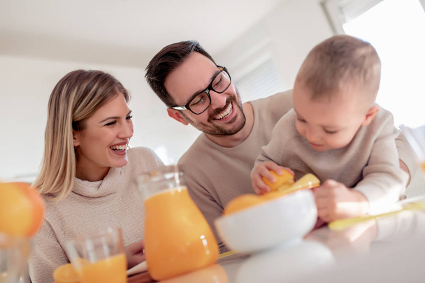Famille faire du jus d'orange frais dans leur cuisine, avoir beaucoup de temps ensemble. - Photo, image