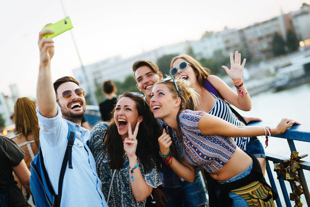 Happy young friends taking group selfie on street - Foto, afbeelding