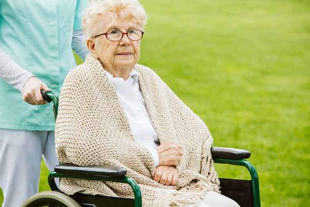 Disabled woman on the wheelchair in the garden - Valokuva, kuva