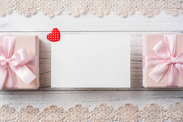 Blank greeting card and gift box with lace frame and red heart on white vintage wooden background for mockup - Foto, afbeelding