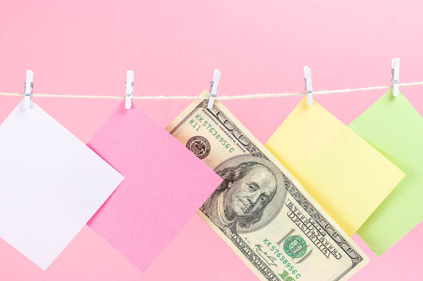 Bunte Papierkarten und Geld hängen isoliert auf rosa Hintergrund. Platz für Ihren Text. - Foto, Bild