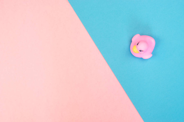 Gummibadeente auf buntem Hintergrund. Draufsicht auf Spielzeug-Gummiente. Spielzeug-Spiel für Kind-Entchen schwimmend. rosa, blauer Hintergrund. - Foto, Bild