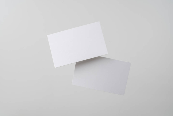White business cards flying in air on grey background for mockup - Valokuva, kuva