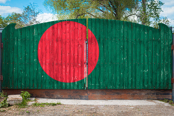 Nahaufnahme der Nationalflagge von Bangladesh an einem Holztor am Eingang zum geschlossenen Gebiet an einem Sommertag. das Konzept der Lagerung von Gütern, die Einreise in ein geschlossenes Gebiet, der Tourismus in Bangladesh - Foto, Bild
