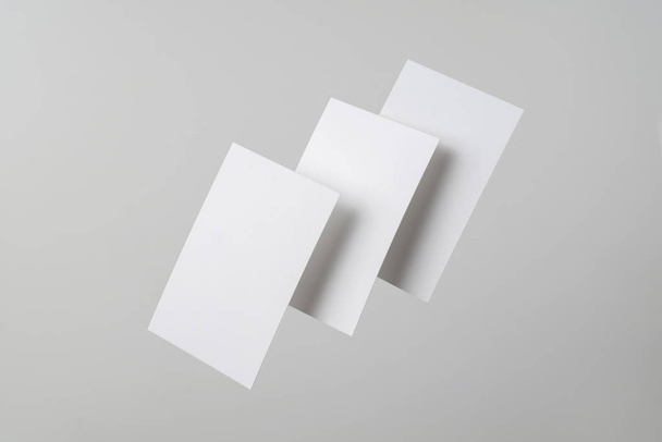 White business cards flying in air on grey background for mockup - Фото, зображення