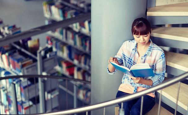 high school student girl reading book at library - Foto, imagen