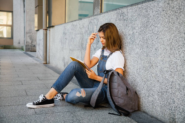 Student girl studying sitting on the floor - Photo, image