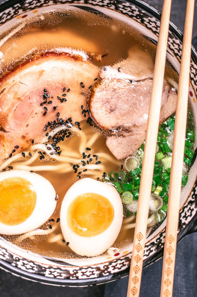 濃い背景に豚肉、卵、スカリオンを使った日本のラーメンスープのうどん - 写真・画像