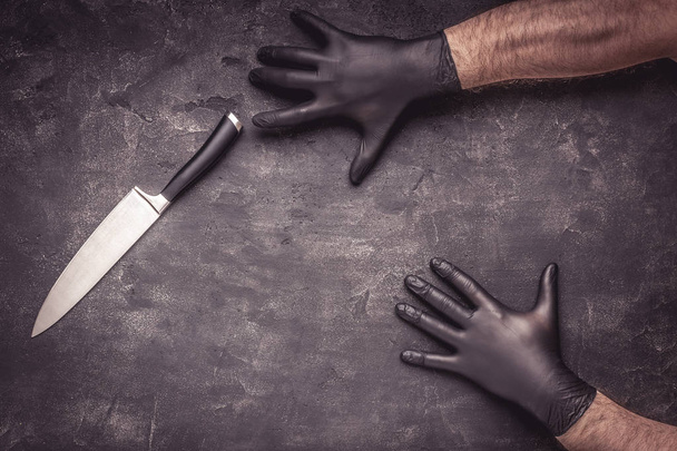 Męskie ręce z czarnym lateks rękawice i nóż na ciemnym tle - Zdjęcie, obraz